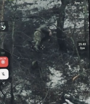 Russian soldier is seen in what looks like a treeline pulling the pin on his grenade and detonating it underneath himself while lying belly down. Powerful explosion lifts his body up and turns it around