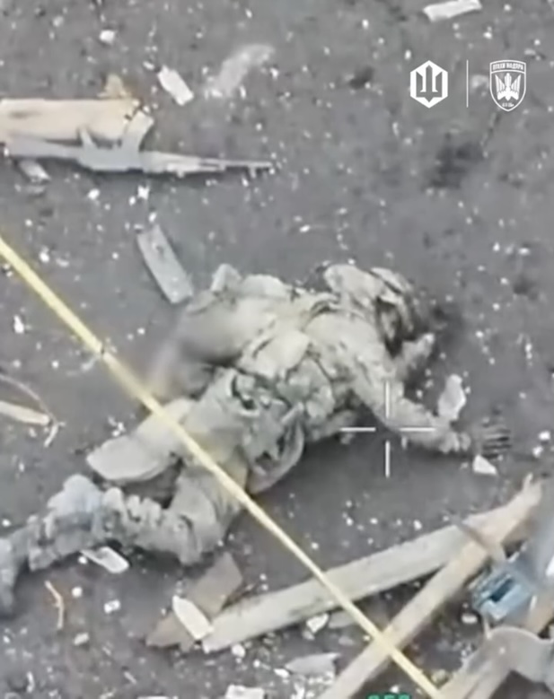 Fully equipped Russian moves alone across the road in ruined settlement, receives close FPV hit. Immobilised, he pulls the pin on his grenade, and leves it right under his head to detonate