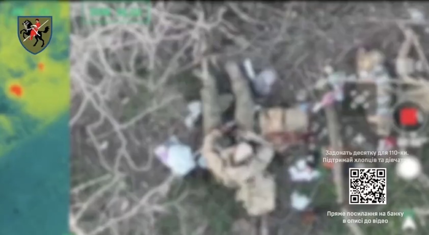 Russian soldier is seen from above apparently fumbling with grenade, although video is blurred. He appears to put it next to his butt and roll to his side before it detonates