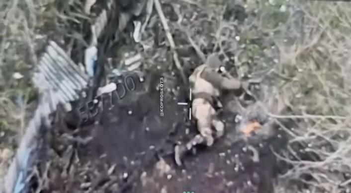 Zero context video cut featuring what looks like Russian soldier shooting himself while lying on his side near some kind of rubble. Video is for some reason stretched vertically